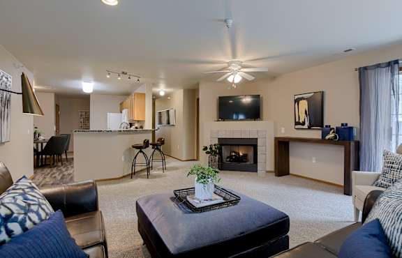 A living room with a fireplace and a flat screen TV mounted on the wall.