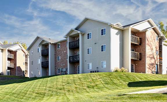 Apartment buildings on a hill with a clear blue sky.