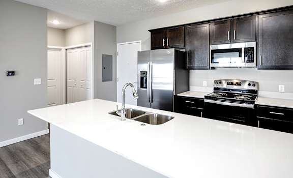 a kitchen with a large white counter top and a sink