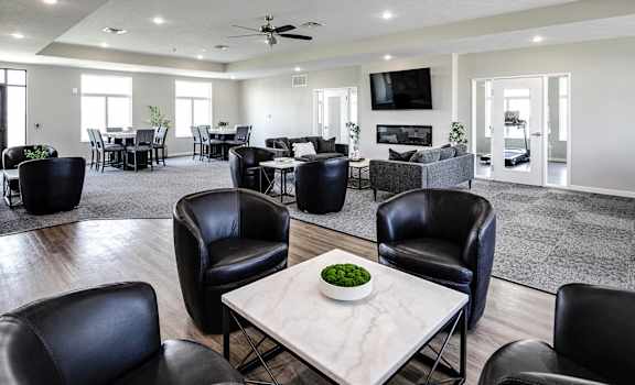 a large living room with black leather chairs and a table