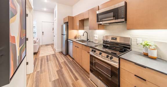 A kitchen with wooden floors and stainless steel appliances.