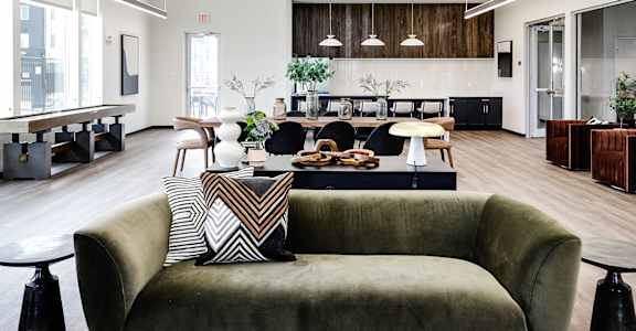 a large living room with a couch and a table in the middle