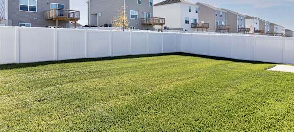 A row of houses with a white fence in front.