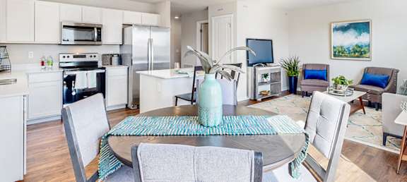 A modern kitchen with a dining table and chairs.