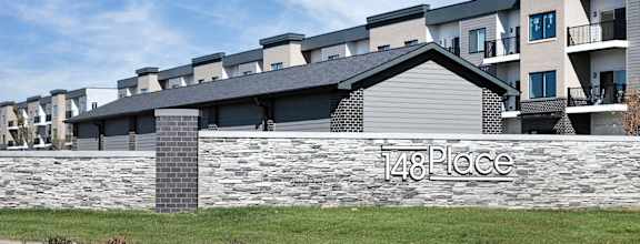 an apartment building with a sign on a stone wall
