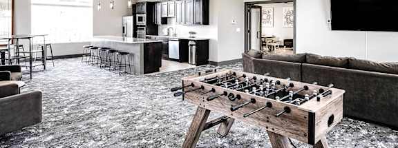 a games room with a foosball table and couches