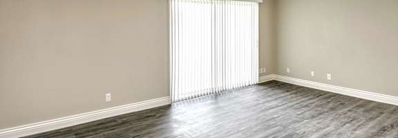 a bedroom with hardwood floors and a large window