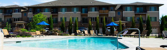 A large swimming pool in front of apartment buildings.