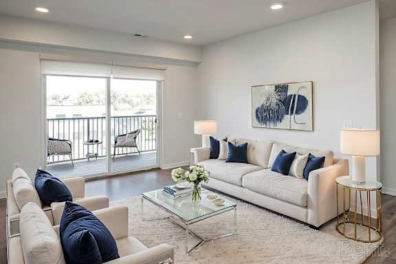 A living room with a white couch, a glass coffee table, and a painting on the wall.