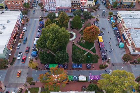 an aerial view of a city street with cars and trees