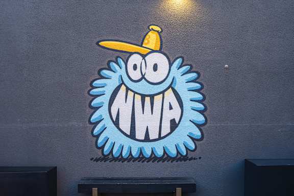 a mural of a monster with a yellow hat on a blue wall