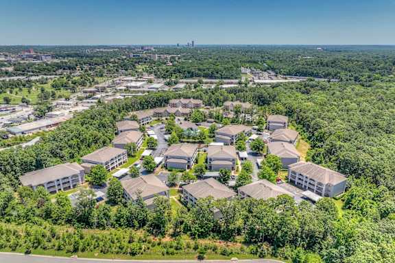 A bird's eye view of a residential area with houses surrounded by greenery.