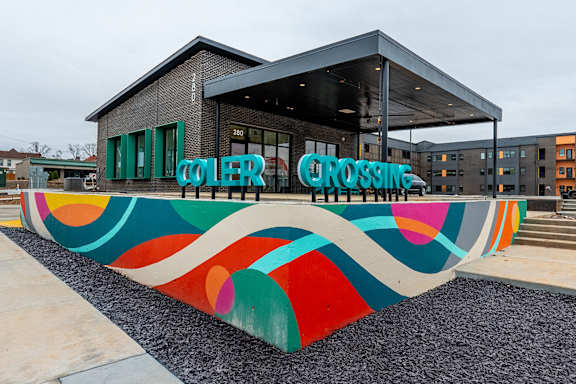 A building with a large mural on the ground in front of it.