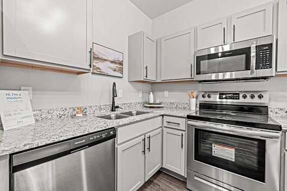 an updated kitchen with stainless steel appliances and granite counter tops