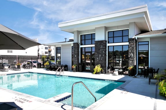a swimming pool in front of a hotel with a building