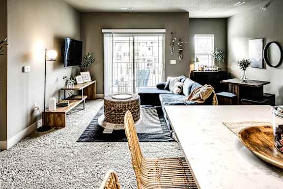 A living room with brown leather chairs and a glass table.