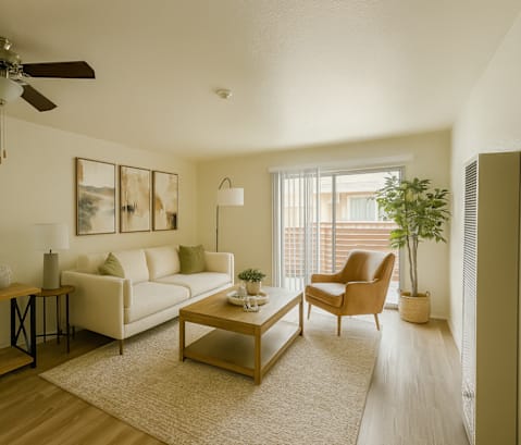 A living room with a white couch, a brown armchair, and a wooden coffee table.