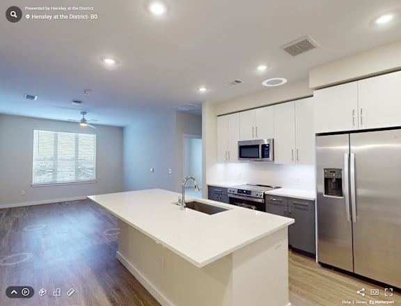 A modern kitchen with stainless steel appliances and white countertops.