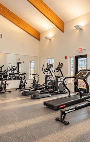 A gym with treadmills, elliptical machines, and exercise bikes.