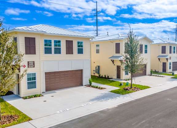 A row of houses with garages and driveways.