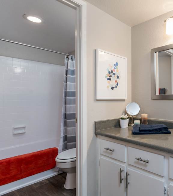 A bathroom with a red towel on the toilet.