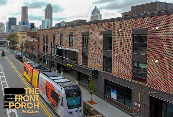 A train is on a track in front of a building.