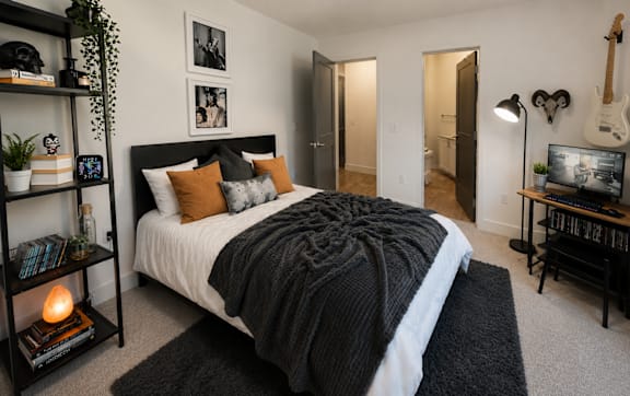 Cozy bedroom with modern finishes, ceiling fan, and generous closet space at The Mill Old Town Apartments.