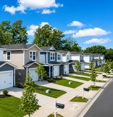 A row of houses with a blue sky and clouds in the background.