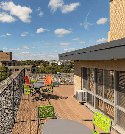 A rooftop patio with a table and chairs overlooks a cityscape at Park Towers, St. Louis Park, 55416.