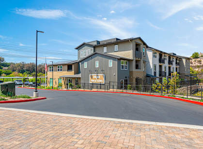 A large apartment complex with a red brick walkway in front.
