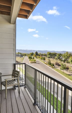 two chairs and a table on a balcony overlooking a road and trees at Parkside at Littleton Village, Littleton, 80122