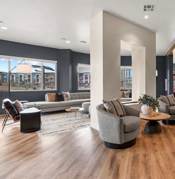 A modern living room with a grey sofa and wooden floors.