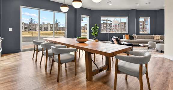 A modern dining room with a large table and chairs.
