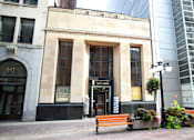 Thumbnail 1 of 4 - A building with a sign that says Stampless is in front of a tall building.