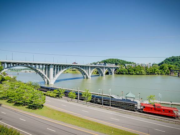 A red train is crossing a bridge over a river.at Maplehurst Apartments, Knoxville