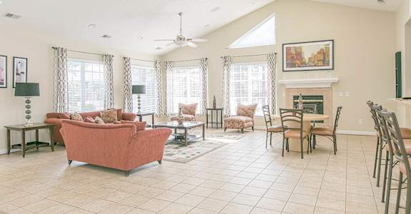 a living room with a fireplace and a ceiling fan
