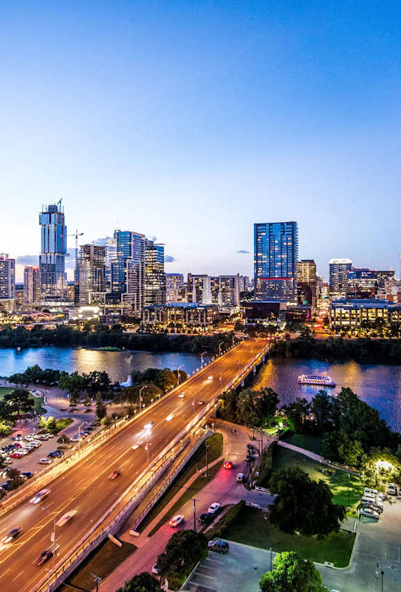 A cityscape with a river and a highway.