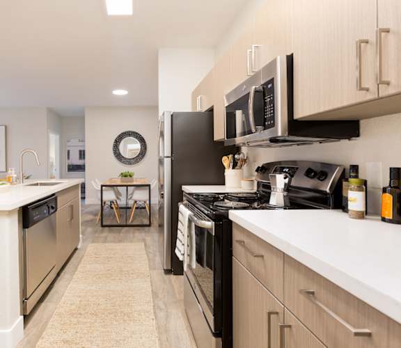 A modern kitchen with black appliances and white countertops.