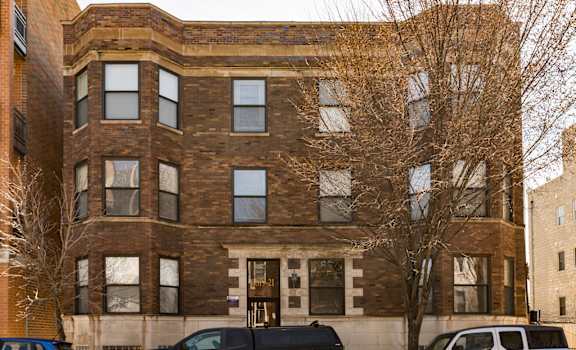A black SUV is parked in front of a brick building.