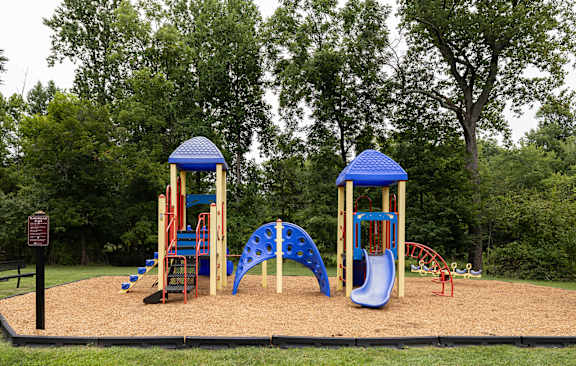 A playground with a blue canopy and a yellow slide.
