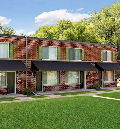 A red brick building with green shutters and a black awning at Era on Excelsior, St. Louis Park, Minnesota