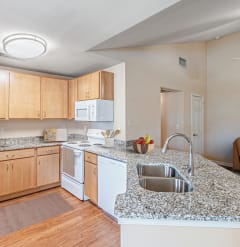 an open kitchen and living room with a granite counter top