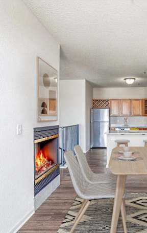 A dining room with a fireplace and a table set for four.