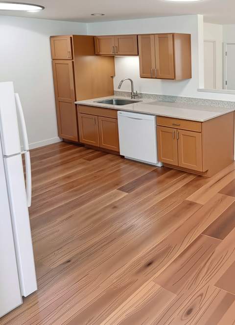 A kitchen with wooden floors and white appliances.