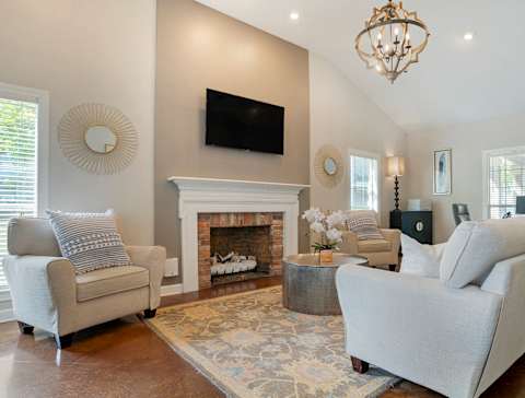 A living room with a fireplace and a flat screen TV mounted on the wall. at Crosswinds Apartments, Mississippi, 39208