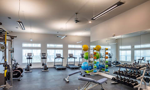 A gym with a variety of exercise equipment and a balloon decoration.