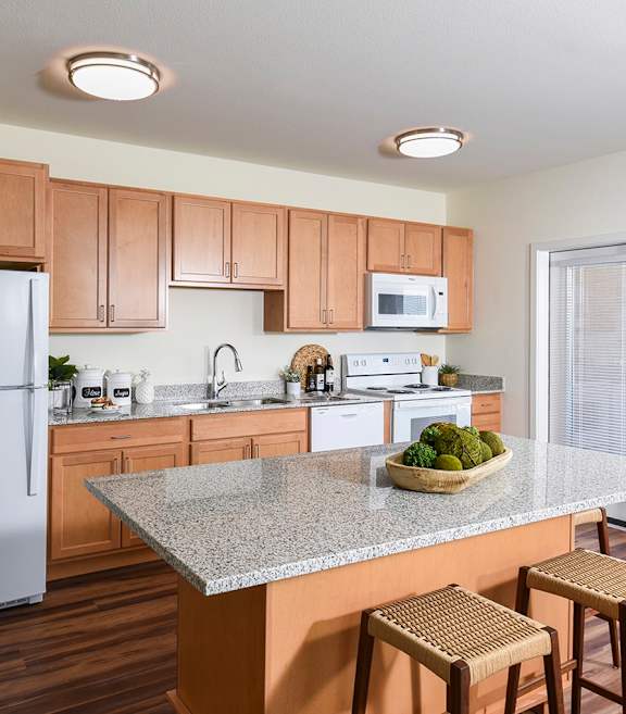 A kitchen with a white refrigerator and wooden cabinets.
