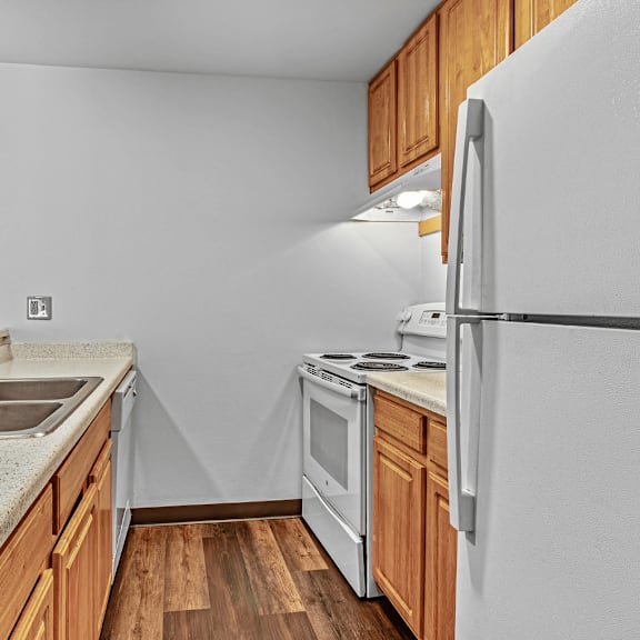A kitchen with wooden cabinets and a white countertop.