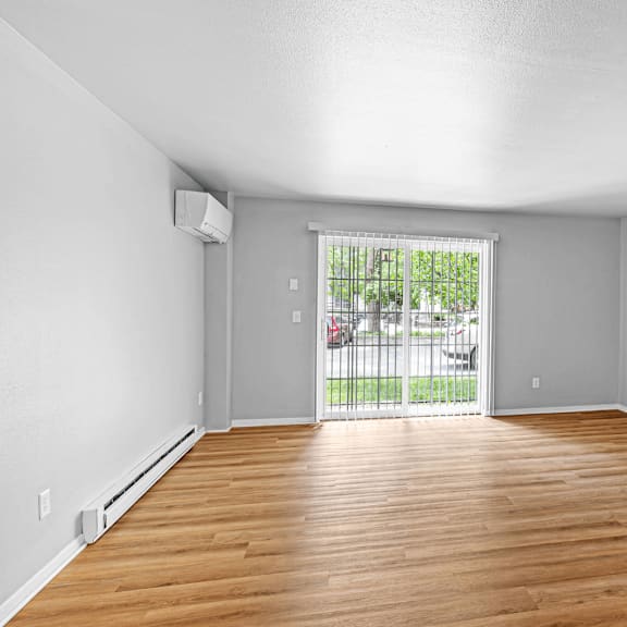 A room with wooden floors and a sliding glass door.