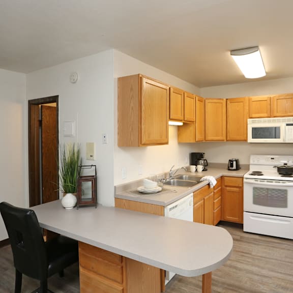 A kitchen with a white refrigerator and wooden cabinets.